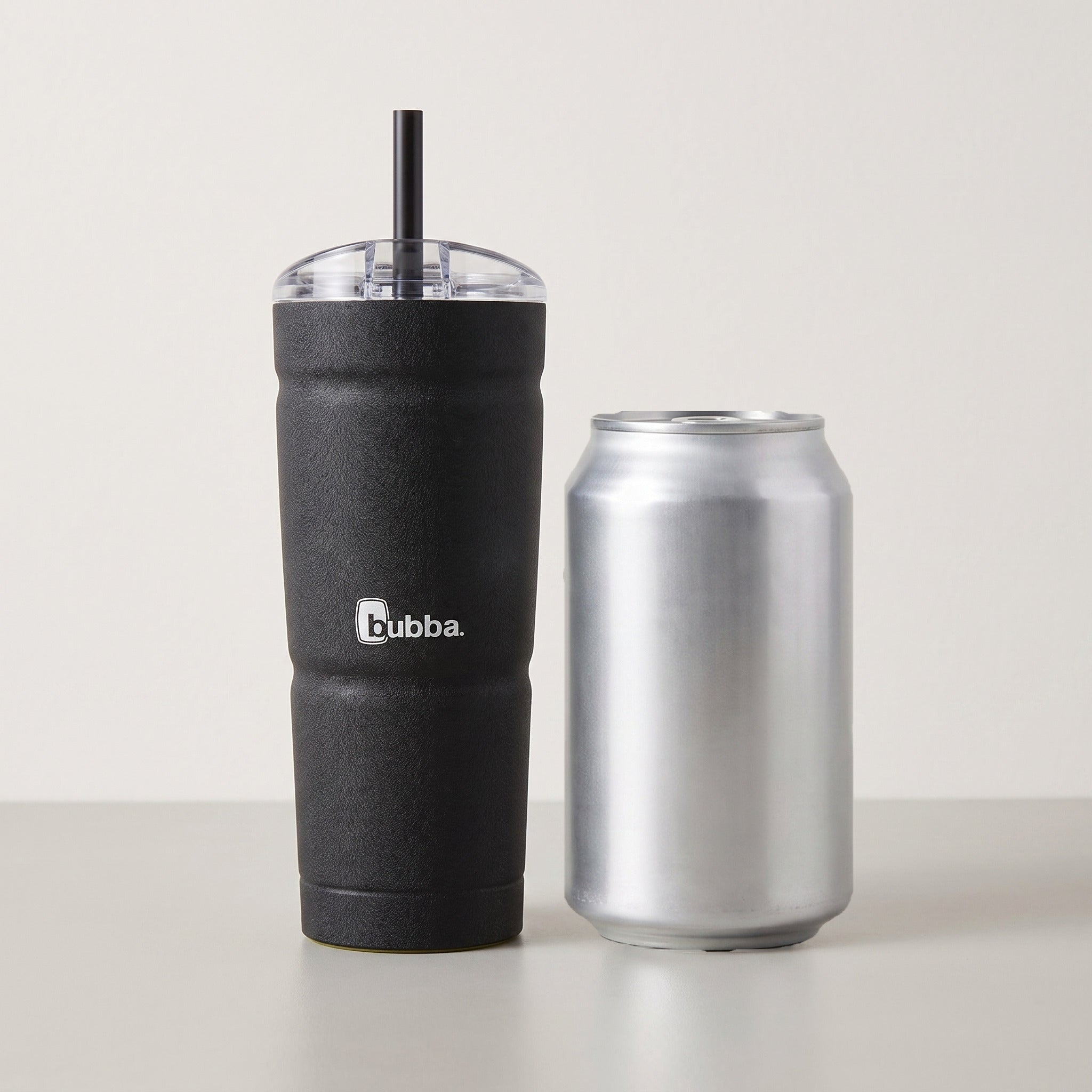 bubba 24 oz Envy S Tumbler in Licorice standing beside a 355 ml can for size comparison. It stands 7.5 in tall.