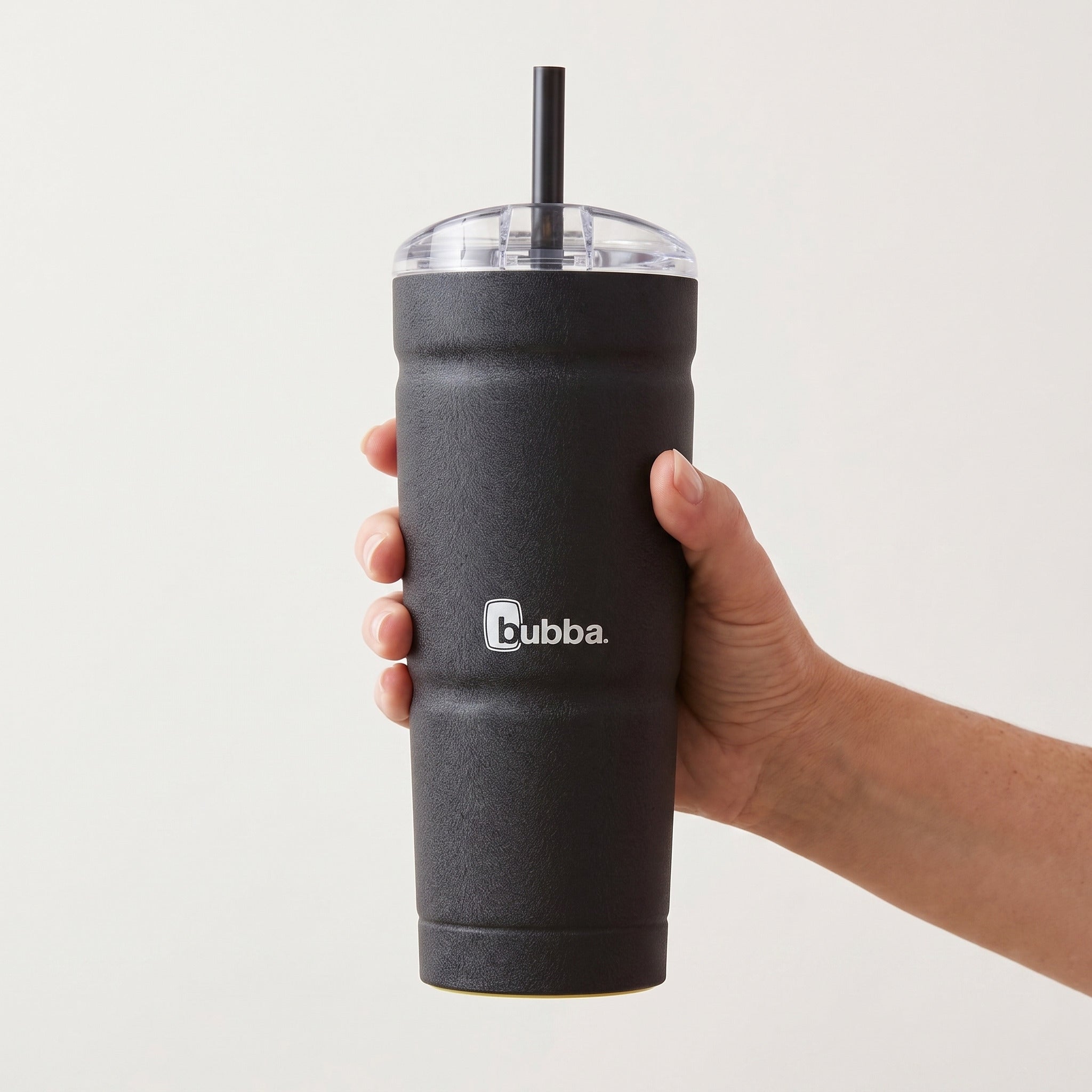 bubba 24 oz Envy S Tumbler in Licorice held in an adult hand, showing its real size. It stands 7.5 in tall.