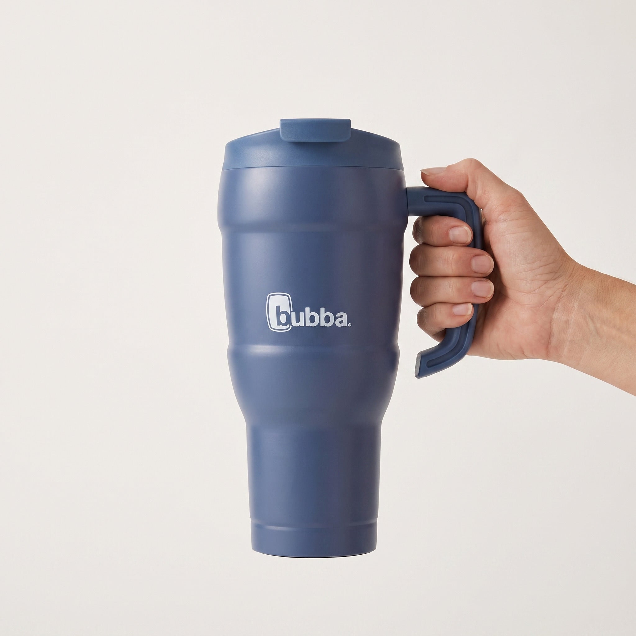 bubba 24 oz Hero XL Tumbler in Indigo held in an adult hand, showing its real size. It stands 10.0 in tall.