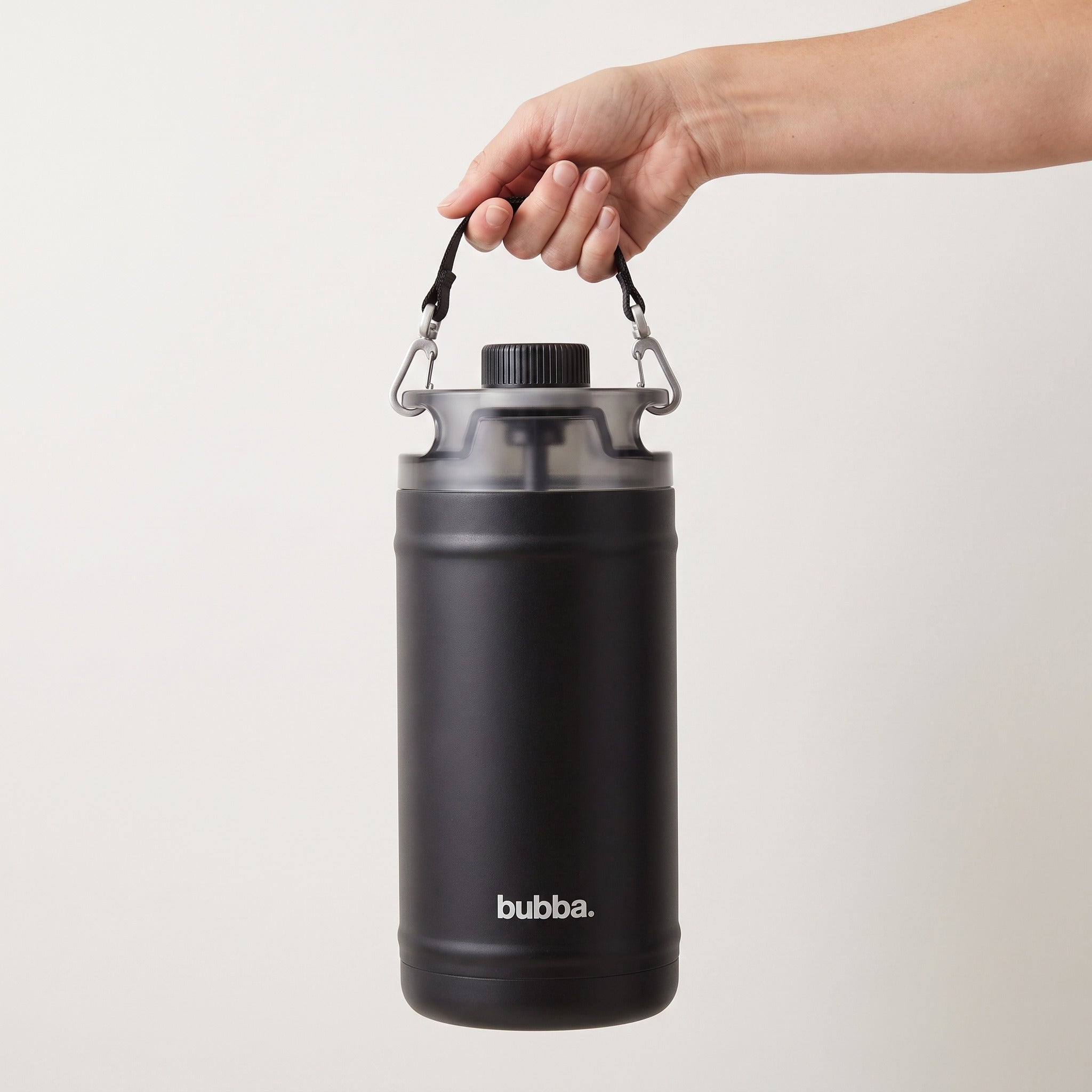 bubba 64 oz Insulated Jug in Office Siren held in an adult hand, showing its real size. It stands 10.2 in tall.
