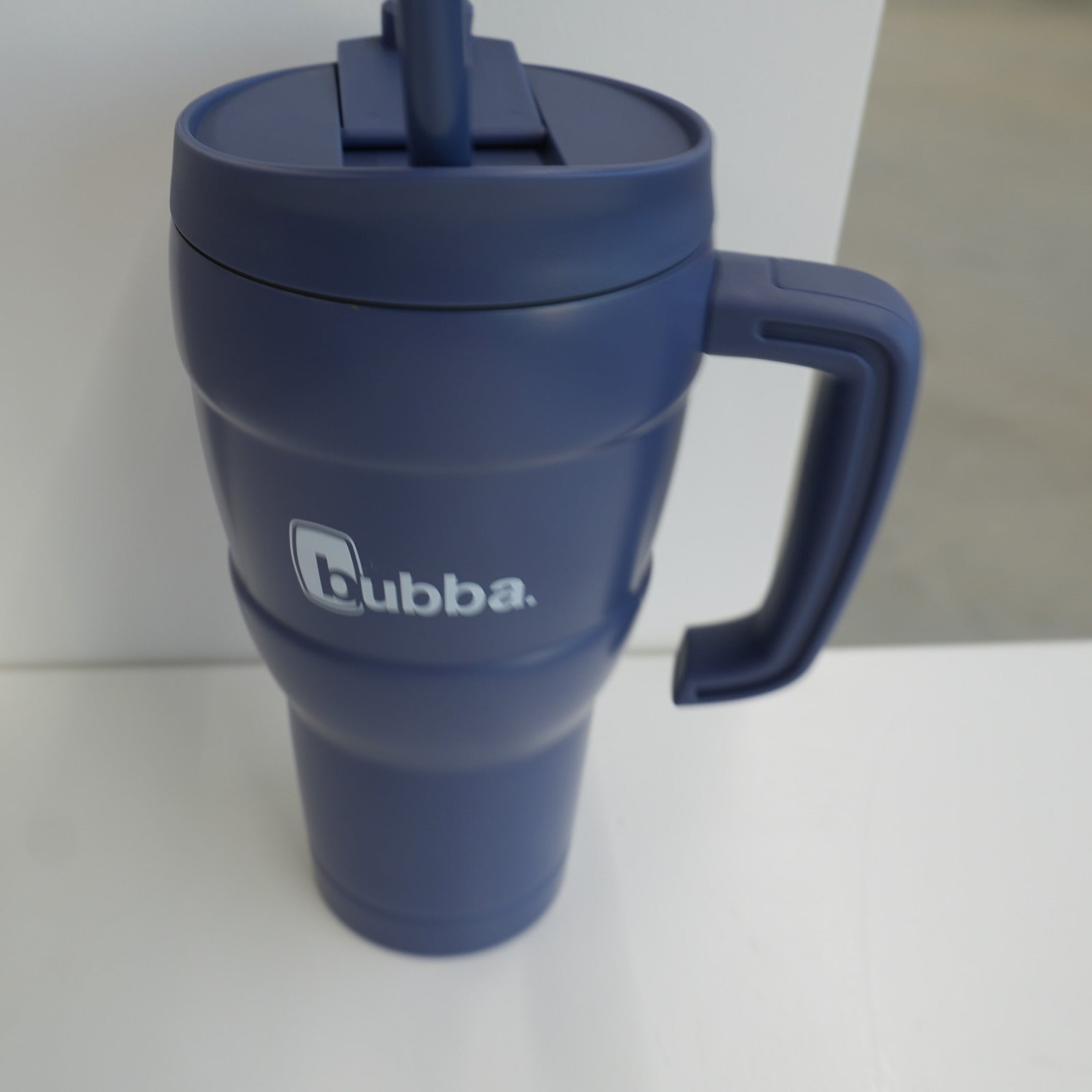 bubba 24 oz Hero XL tumbler in Indigo, three-quarter view with the straw lid fitted and the moulded handle to the right
