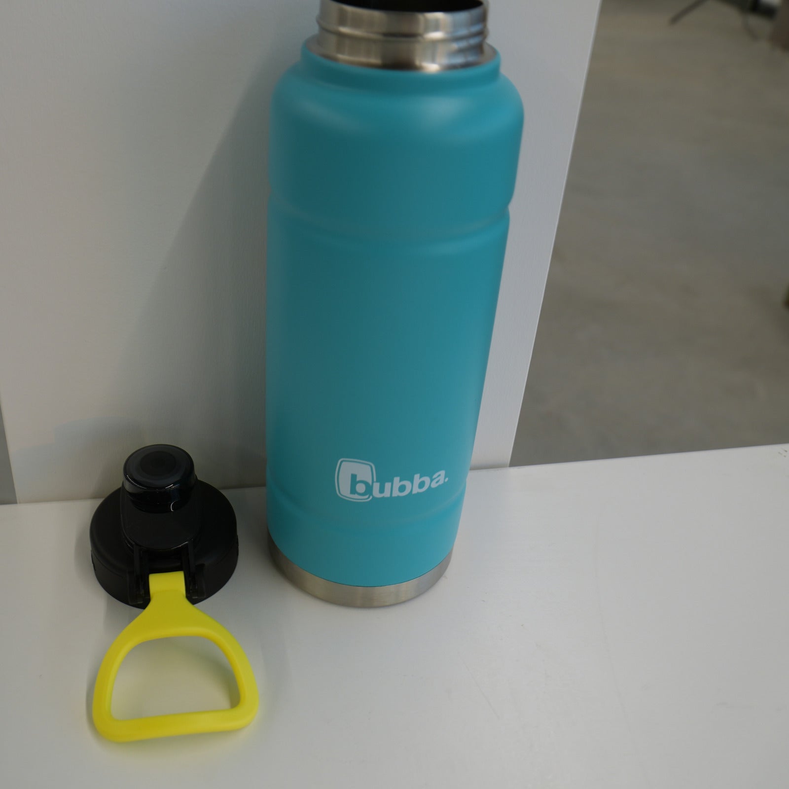 bubba 40 oz Trailblazer insulated bottle in Scuba teal standing upright with the push-button lid and yellow carry loop beside it